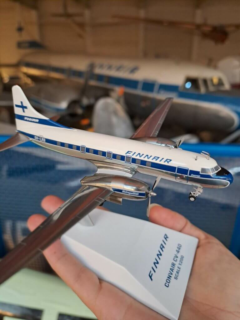 Convair CV-440 pienoismalli kädellä, taustalla oikea Convair-lentokone Ilmailumuseon näyttelyssä.