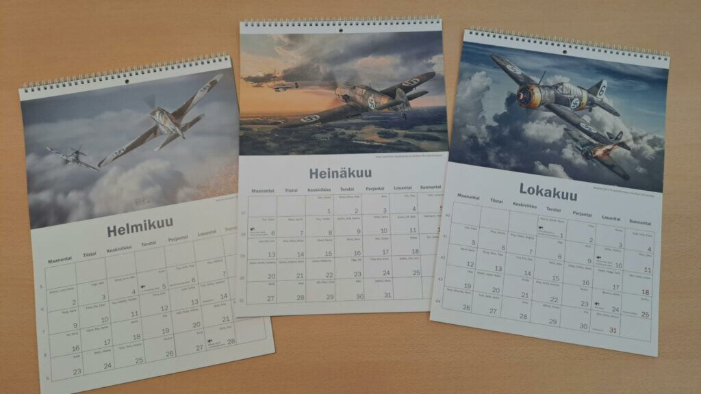 Kolme Petri Kaupin kalenteria, esillä helmi-, heinä ja lokakuut.