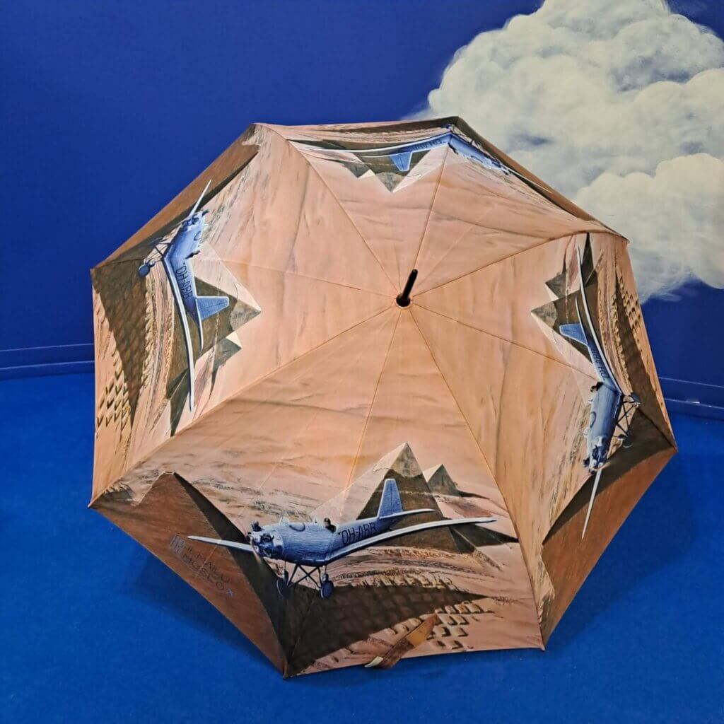 Sateenvarjo auki kuvattuna. Kuvitus täyttää kaksi sektoria, eli kuva toistuu varjossa neljä kertaa.