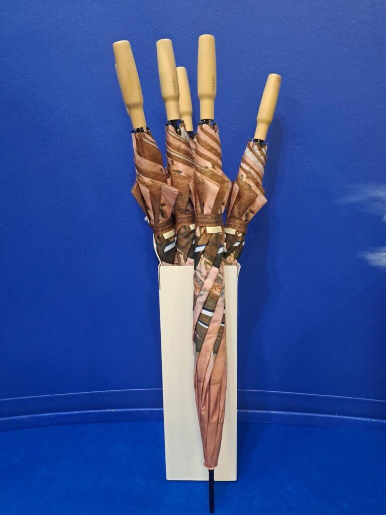 Sateenvarjoja telineessä pystyssä ja yksi telineen ulkopuolella.