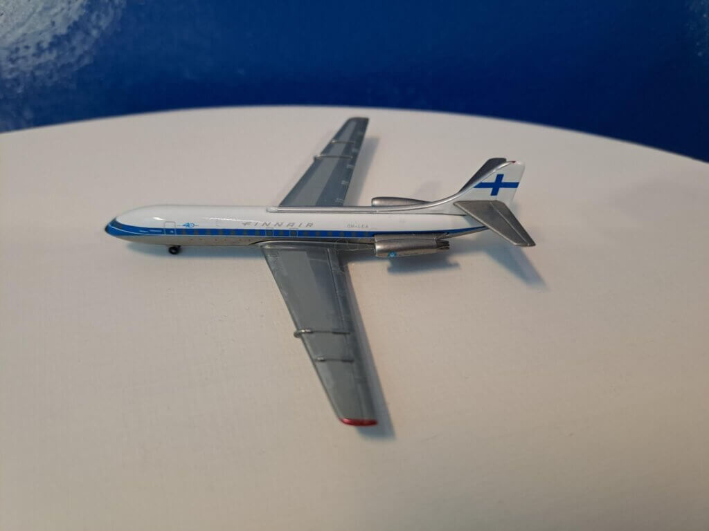 Finnair Caravelle -pienoismalli valkoisella pöydällä, takana sininen seinä.