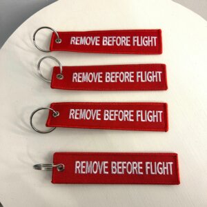 Neljä punaista avaimenperää valkoisella Remove before flight -tekstillä