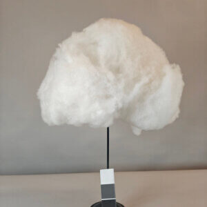 Valkoinen pilvi, muistuttaa hattaraa. Kuvattu jalustan päällä.