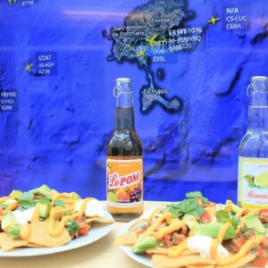 Kahdet loaded nacho -annokset ja limut pöydällä, taustalla Flight Radarin näkymä Ibizasta.