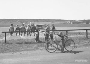 Juliste, jossa joukko poikia ihailee Veljekset Karhumäki Oy:n Lockheed L-18-56 Lodestar -konetta.