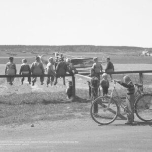 Juliste, jossa joukko poikia ihailee Veljekset Karhumäki Oy:n Lockheed L-18-56 Lodestar -konetta.